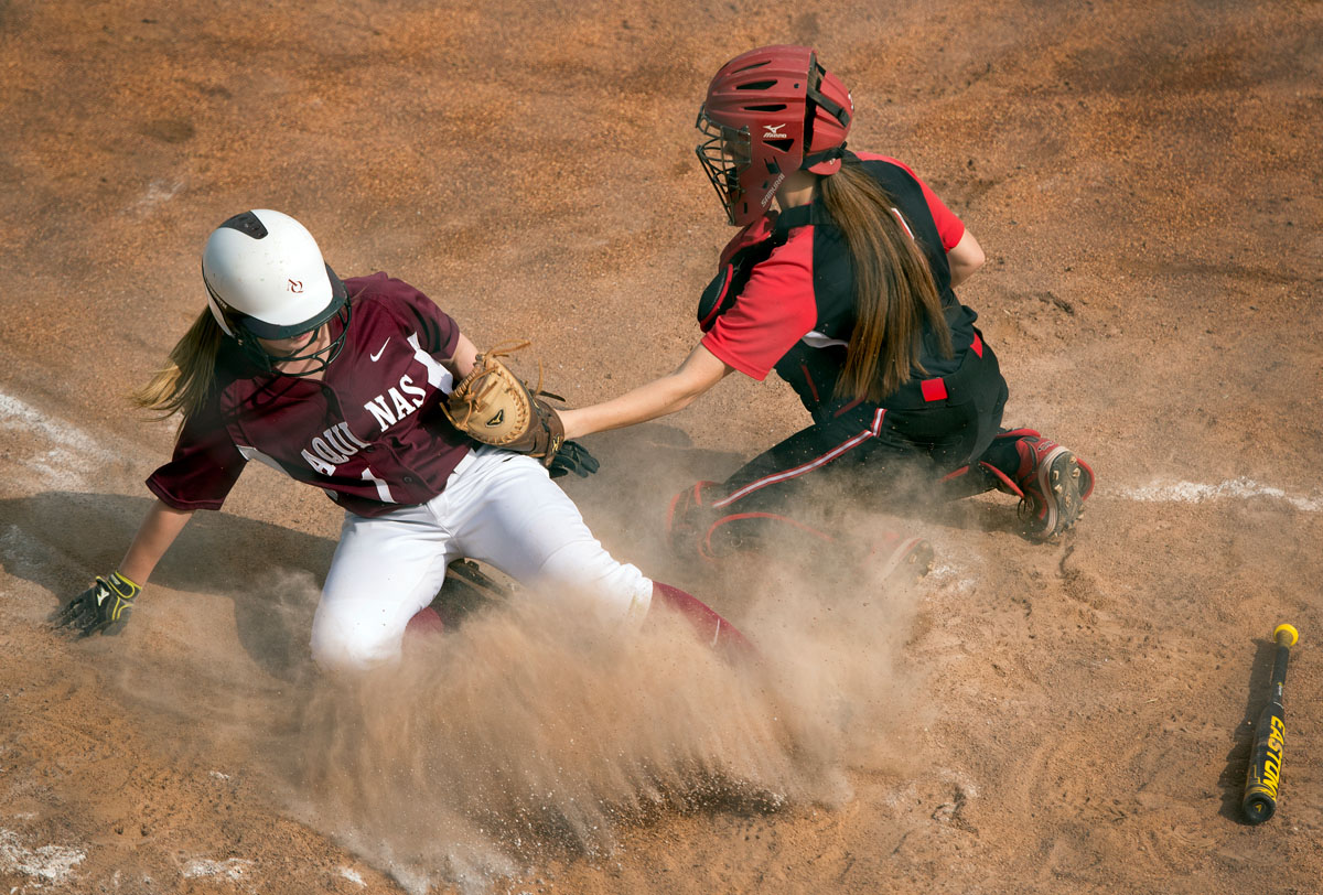 Megan Hildebrand slides safely into home plate to score in the fifth inning of Aquinas Institute’s 5-3 loss to Geneva May 29 in the Section Five Class A2 championship game at the State University of New York at Brockport.