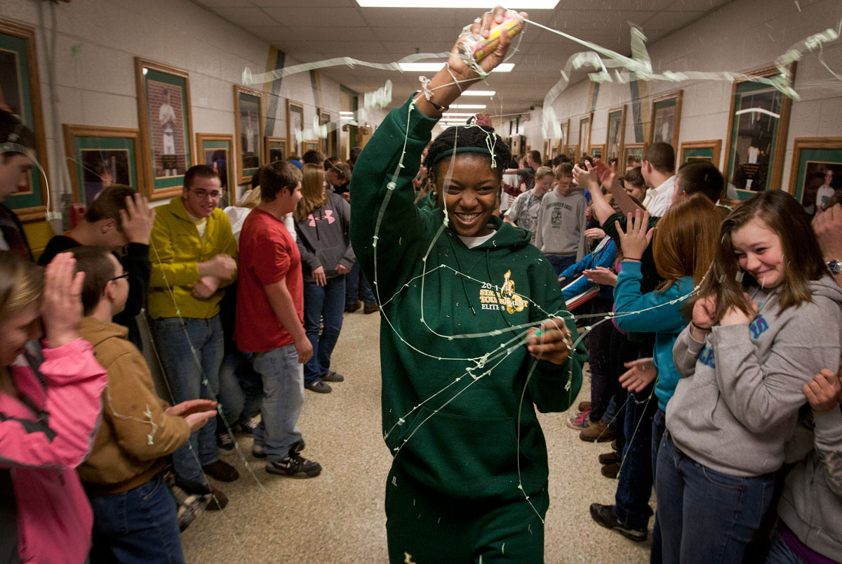 Leading her teammates to the bus bound for the State Girls Basketball Tournament, senior Shay Walker sprays silly string on students lining the hallways of Greenbrier East High School in Lewisburg, W. Va., Wednesday, March 9, 2011.