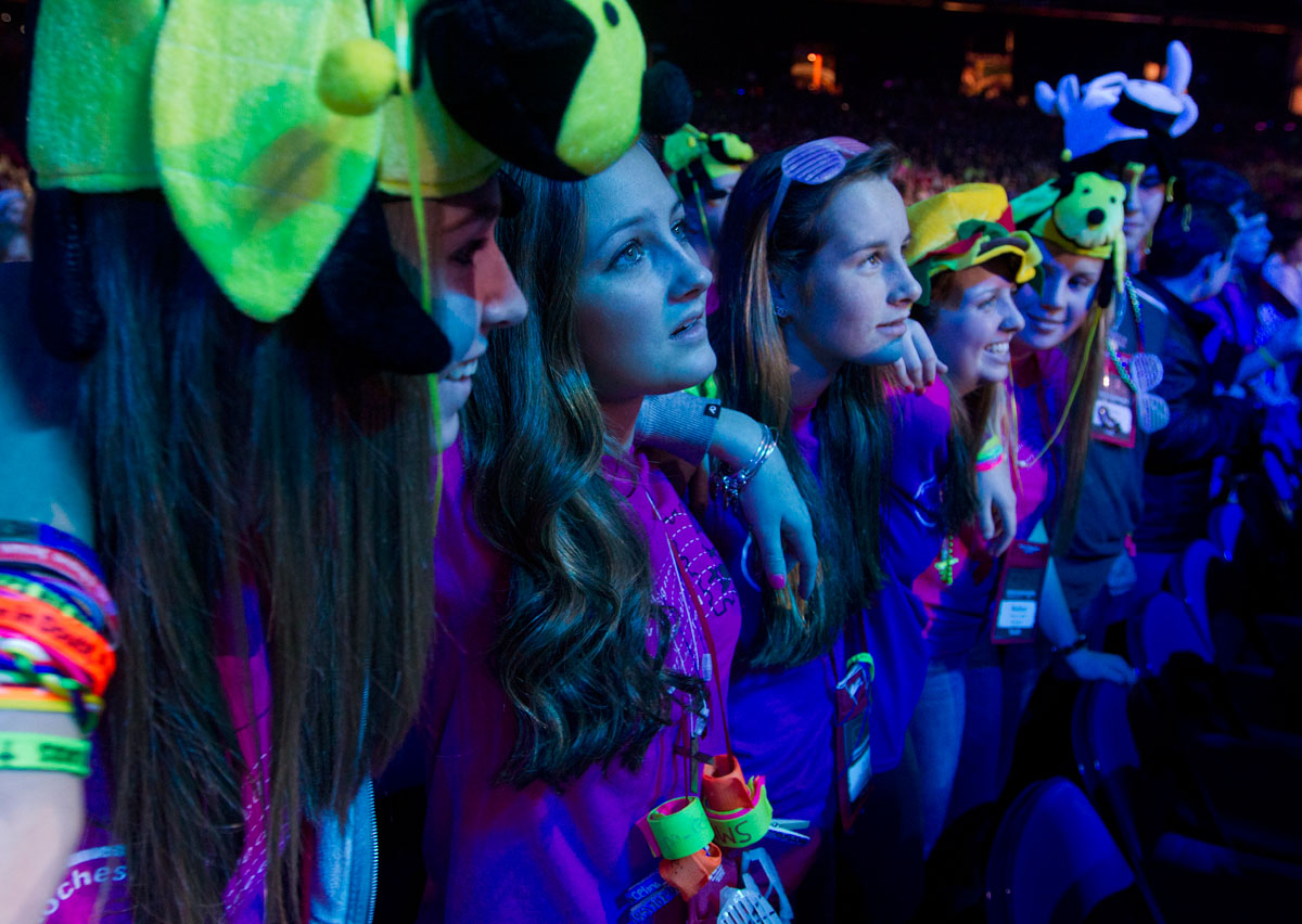 Jenna Brooks (from left), Celina Rescott, Judy Rescott, Maggie Flurschutz and Mallory Colella dance and sing-along to the 2013 theme song for the National Catholic Youth Conference at the end of NCYC's opening ceremony Nov. 21, 2013, at Lucas Oil Stadium in Indianapolis. 