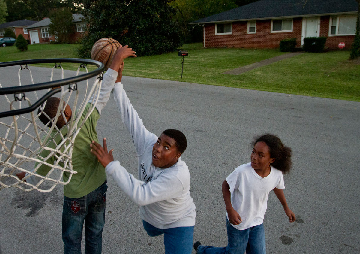 Eleven-year-old Liorell Gray tries to dunk over his cousin 13-year-old Thomas Maxey while playing basketball with their soon-to-be cousin, 12-year-old Meikiel Ya Monday, Oct. 8, 2012. The three were playing outside of Gray's home on Gatewood Drive in Bowling Green.