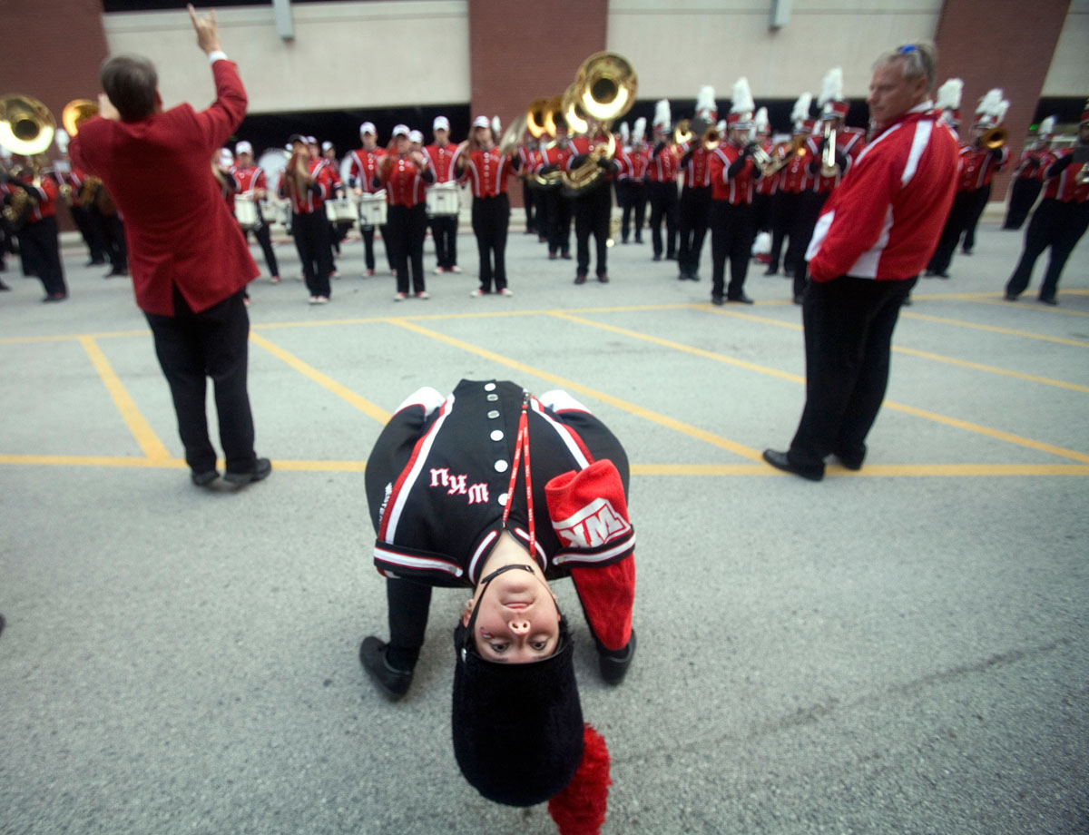 Magnolia senior Aleshia Akin practices a backbend before a football game Oct. 17, 2009, while the Big Red Marching Band rehearses behind her outside Diddle Arena on the campus of Western Kentucky University. A backbend to touch a plume to the field before football games is a tradition for field commanders at Division 1 schools. 