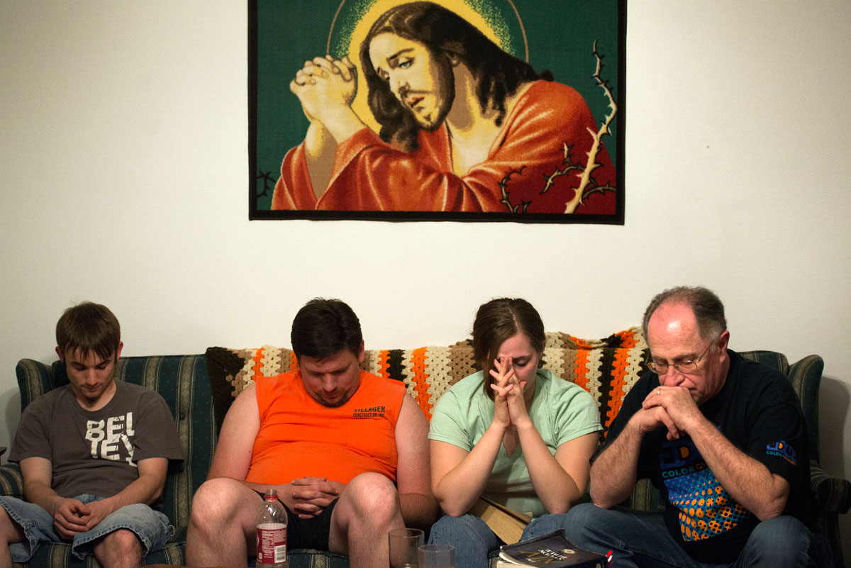 Jonathan Willistein (from left), James Pike, Alice Swarthout and Jim Stocks pray at the end of a Bible study May 20, 2014, at the house they stayed at in Louisa, Ky, during a mission trip to the Appalachian region.