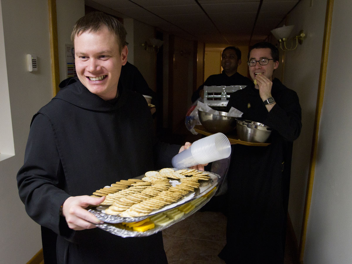Novices Bradley Jensen (left) and Matthew Sprauer carry snacks back to the monastery kitchen at Saint Meinrad Archabbey after a party to celebrate the feast day of St. Cletus April 26, 2013. The monks celebrated the feast in honor of a monk who took the name Cletus after joining their monastery in Saint Meinrad, Ind. The monks are given a new name when they profess temporary vows as Benedictine monks after one year as novices.